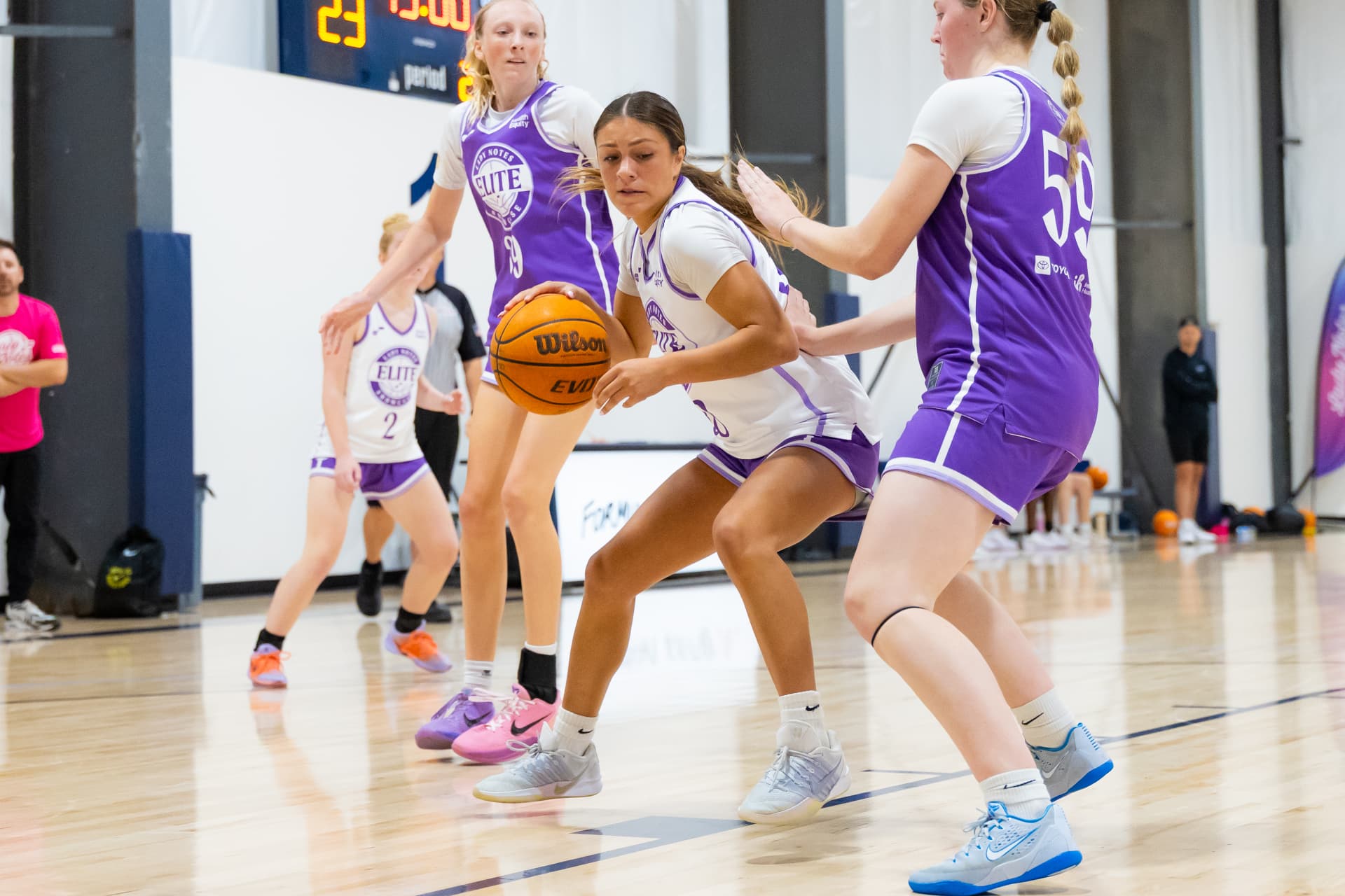 Lady Notes player driving between defenders toward the basket