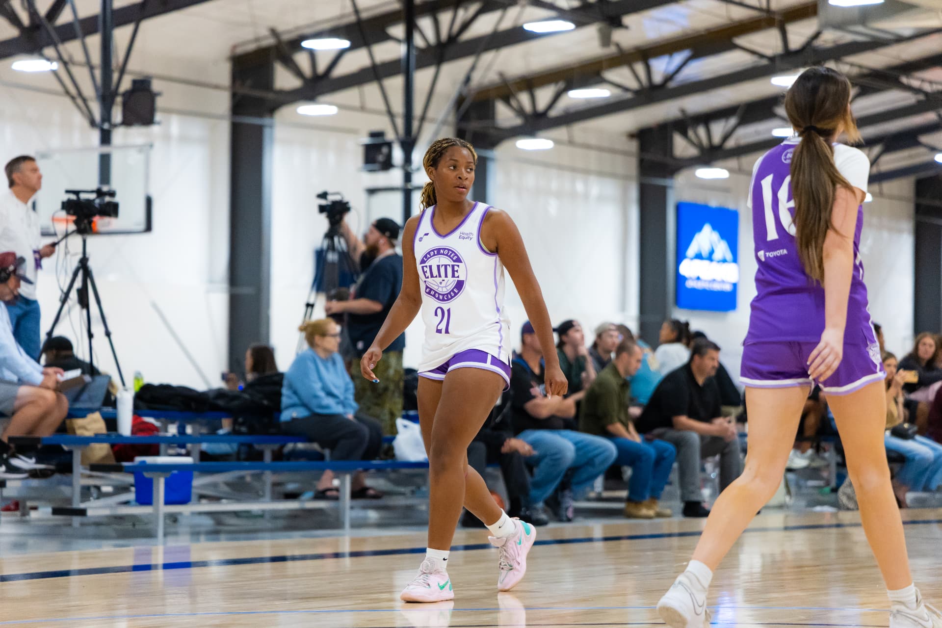 Lady Notes players in white and purple uniforms on the court